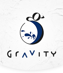 Gravity Winery Logo. A navy blue stylized lowercase G, the bottom of the g is enlarged to create a bowl shape, with wine splash drops inside. The word Gravity is below in a playful sans-serif font and features offset letters.