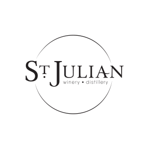 St. Julian Winery logo. A serif text says St. Julian Winery & Distillery. The text overlays a simple circle. The logo is black and white.